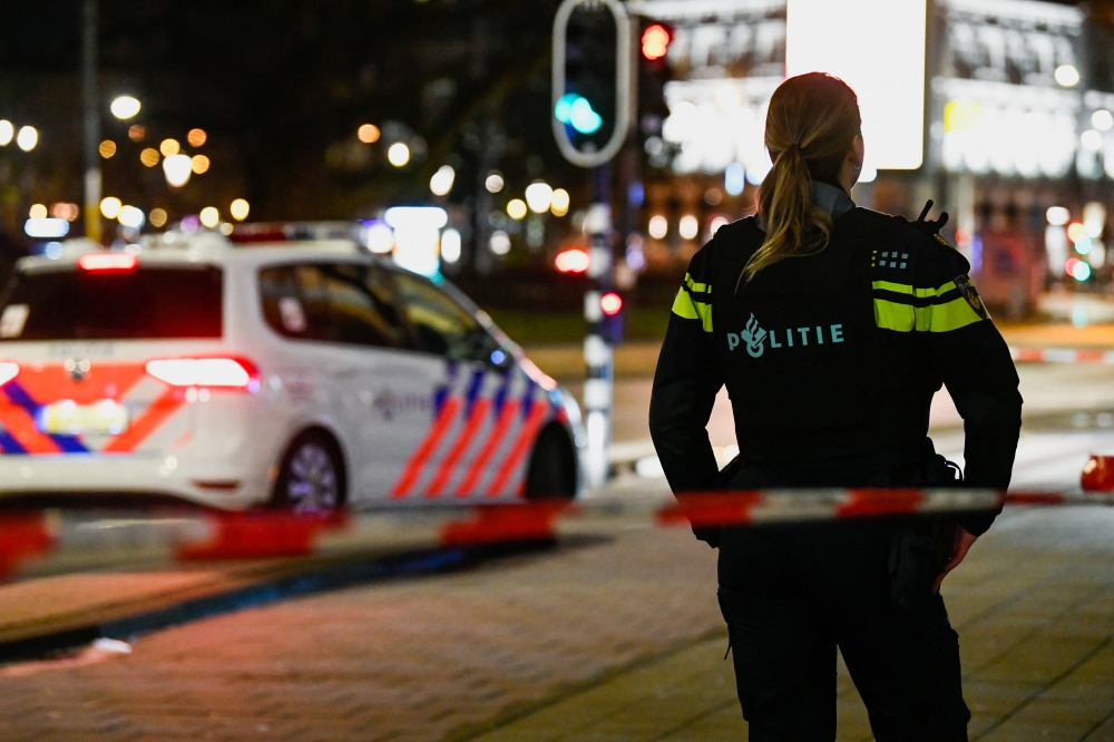 A police officer stands near an Apple store in central Amsterdam during a hostage incident in the store, in Amsterdam, Netherlands February 22, 2022. Reuters/Piroschka van de Wouw
 