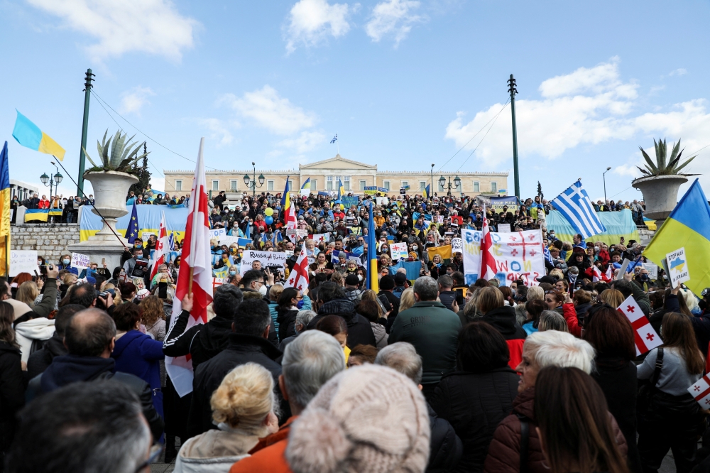 Ukrainians living in Greece hold Ukrainian flags and placards during a protest against Russia's massive military operation in Ukraine, in Athens, Greece, February 27, 2022. REUTERS/Louiza Vradi