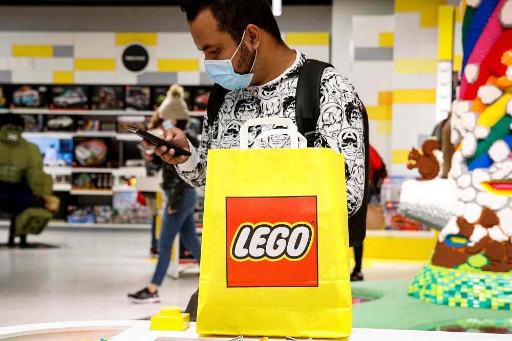  A customer uses his phone while shopping in the 5th Avenue Lego store in New York City, U.S., September 28, 2021. Reuters/Brendan McDermid/File Photo