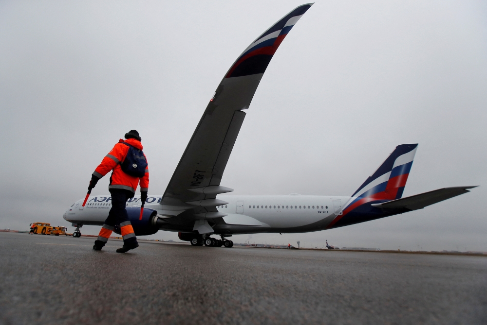 FILE PHOTO: An employee walks past the first Airbus A350-900 aircraft of Russia's flagship airline Aeroflot during a media presentation at Sheremetyevo International Airport outside Moscow, Russia March 4, 2020. REUTERS/Maxim Shemetov/File Photo