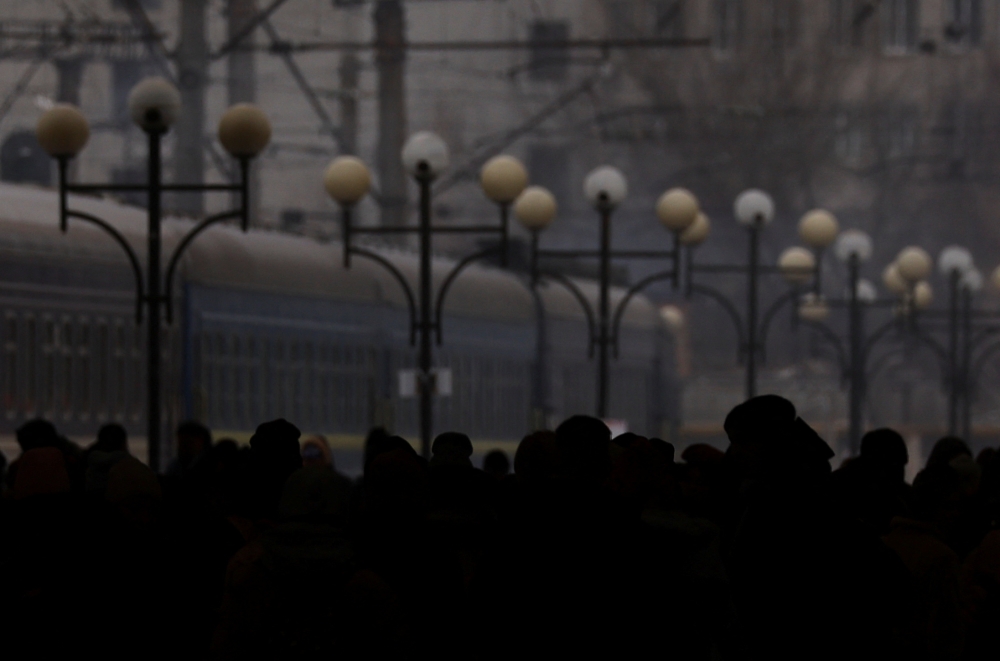 Silhouettes of people waiting on a platform for a train heading to Poland are seen as refugees flee Russia's invasion of Ukraine, in the train station in Lviv, Ukraine March 5, 2022. REUTERS/Kai Pfaffenbach