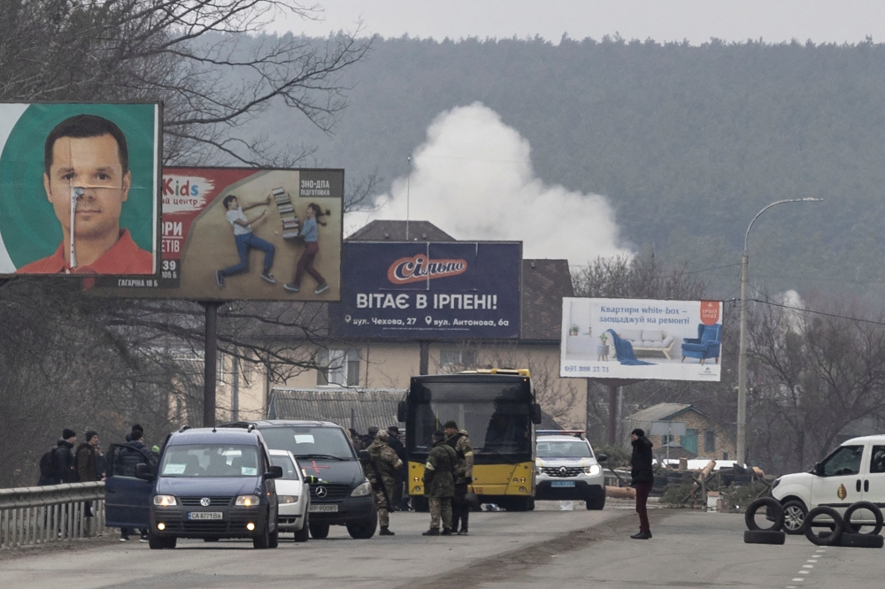 Smoke is seen after an artillery impact near a bridge, the only escape route used by locals to leave the town of Irpin, while Russian troops advance towards the capital, in Irpin, near Kyiv, Ukraine March 6, 2022. REUTERS/Carlos Barria
