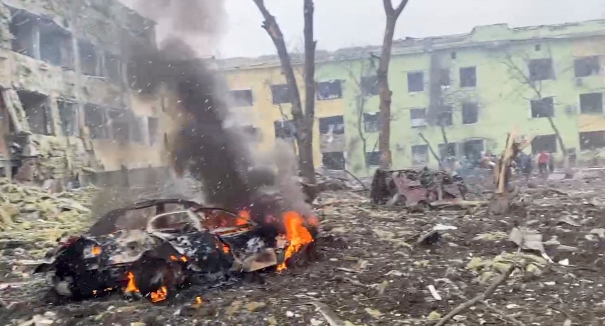 A car burns after the destruction of Mariupol children's hospital as Russia's invasion of Ukraine continues, in Mariupol, Ukraine, March 9, 2022 in this still image from a handout video obtained by Reuters. Ukraine Military/Handout via REUTERS 