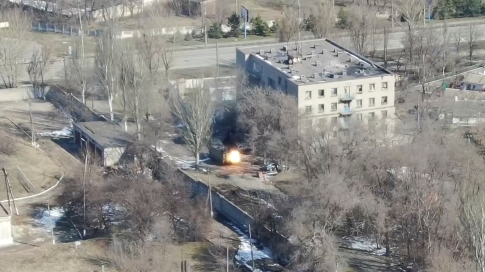 An aeriel view shows an armoured vehicle shoot rounds next to a building, as Russia's invasion of Ukraine continues, in Maripuol, Ukraine as uploaded on March 13, 2022, in this handout drone video obtained by Reuters on March 13, 2022. Azov Mariupol/Handout via Reuters 