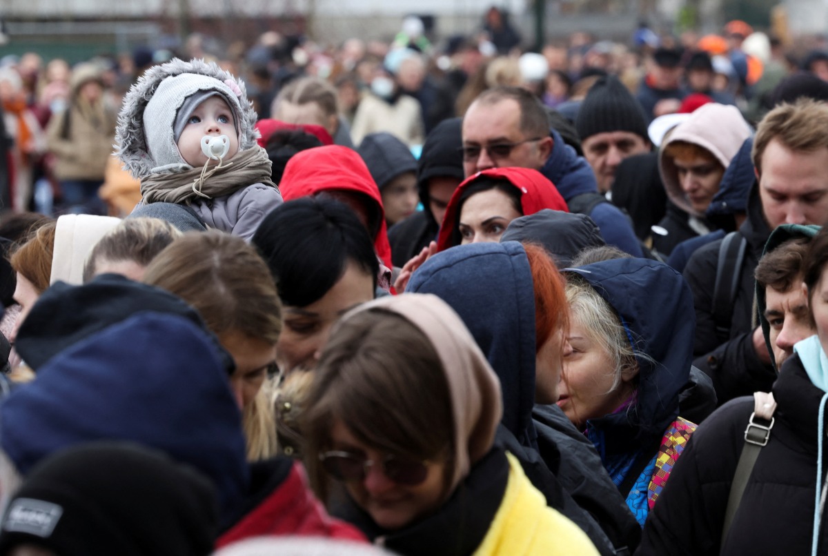 People wait outside an immigration office after fleeing from Ukraine to Belgium, following Russia's invasion of Ukraine, in Brussels, Belgium March 15, 2022. REUTERS/Yves Herman
