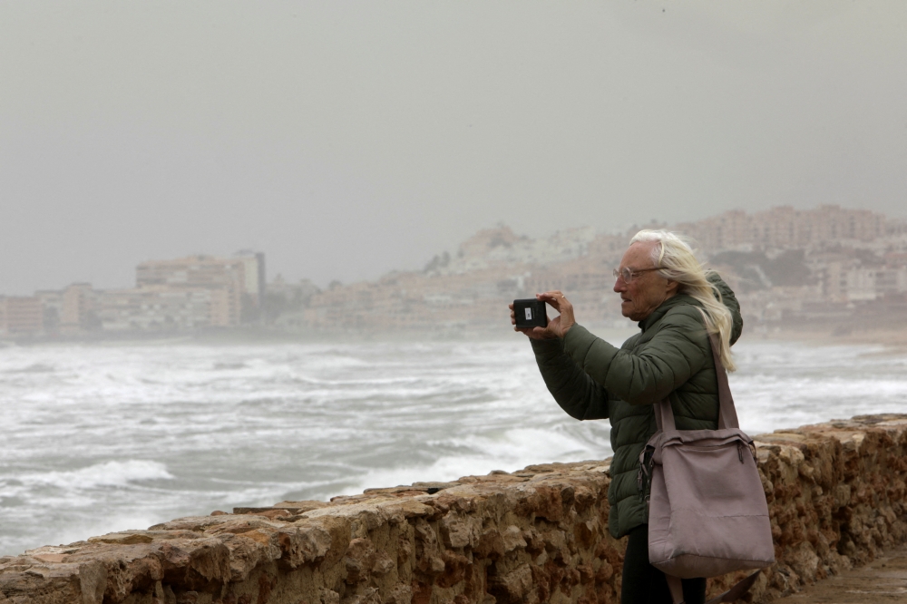Tourists take pictures during storm Celia on La Mata beach, in Torrevieja, Spain March 15, 2022. REUTERS.