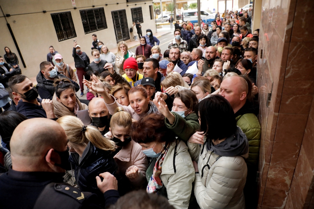 Ukrainian refugees queue to get one of the 100 daily appointments at the documentation office to apply for temporary protection approved by the European Union that allows residence and a work permit, in Torrevieja, Spain March 15, 2022. REUTERS/Eva Manez