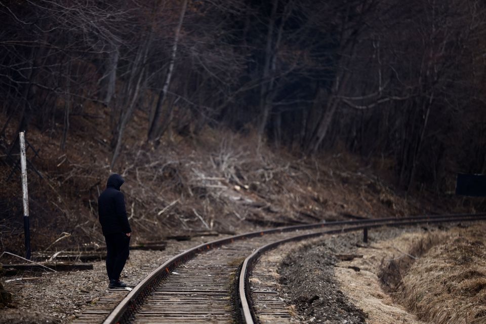 A man walks near railway tracks after crossing the border between Poland and Ukraine, after fleeing the Russian invasion of Ukraine, in Kroscienko. Reuters photo