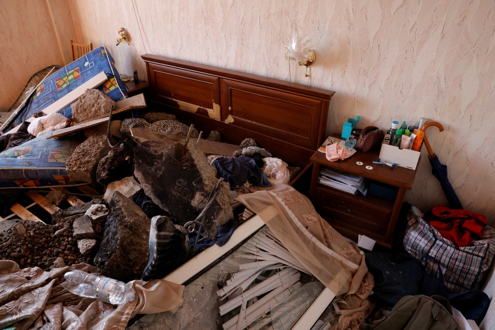 Chunks of concrete are seen on a bed in a bedroom in a damaged apartment after an intercepted missile hit a residential building, following Russia's invasion of Ukraine, in Kyiv, Ukraine March 17, 2022. Reuters/Thomas Peter