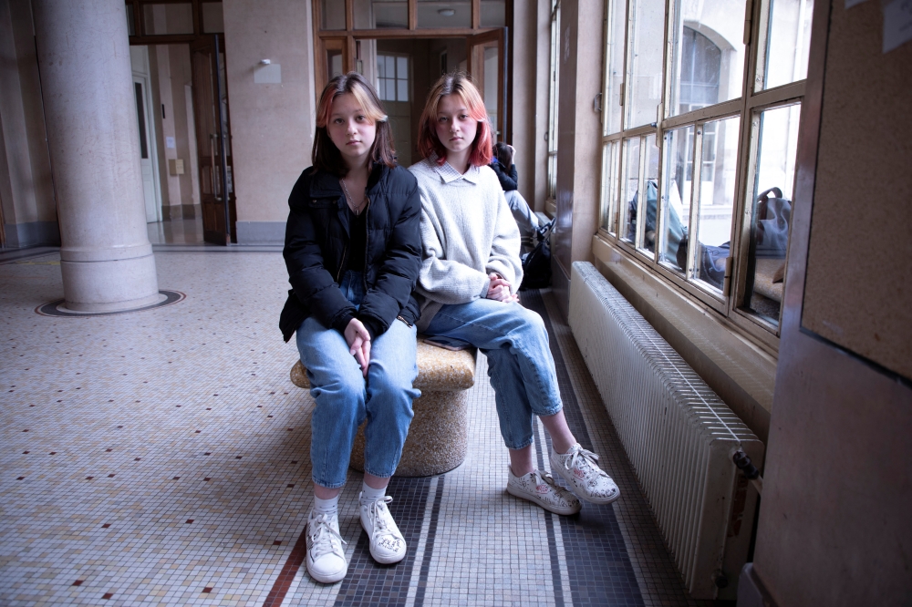 Ukrainian teenagers Sasha and Masha Litkovska pose for Reuters at Jean de la Fontaine High School, after fleeing from Ukraine to France, following Russia's invasion of Ukraine, in Paris, France, March 17, 2022. REUTERS/Yiming Woo