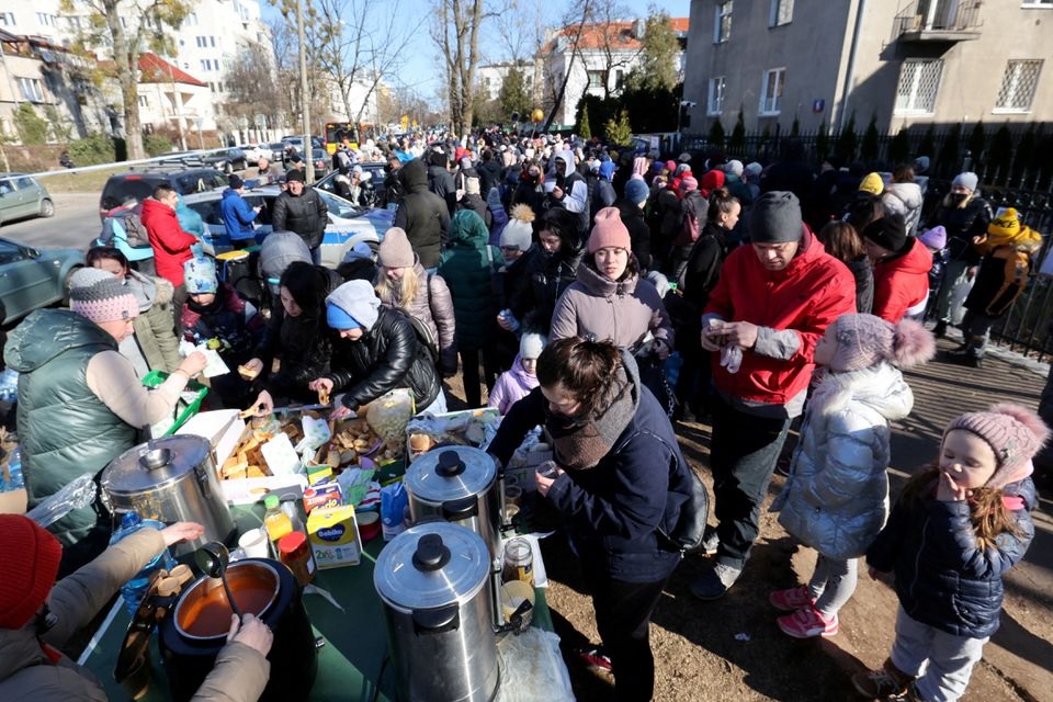 Refugees eat as they wait in front of the Ukrainian consulate in Warszawa, Poland March 10, 2022. Kuba Atys/Agencja Wyborcza.pl via REUTERS
