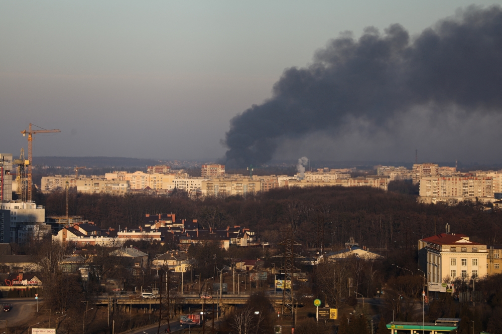 Smoke rises above buildings near Lviv airport, as Russia's invasion of Ukraine continues, in Lviv, Ukraine, March 18, 2022. REUTERS/Roman Baluk