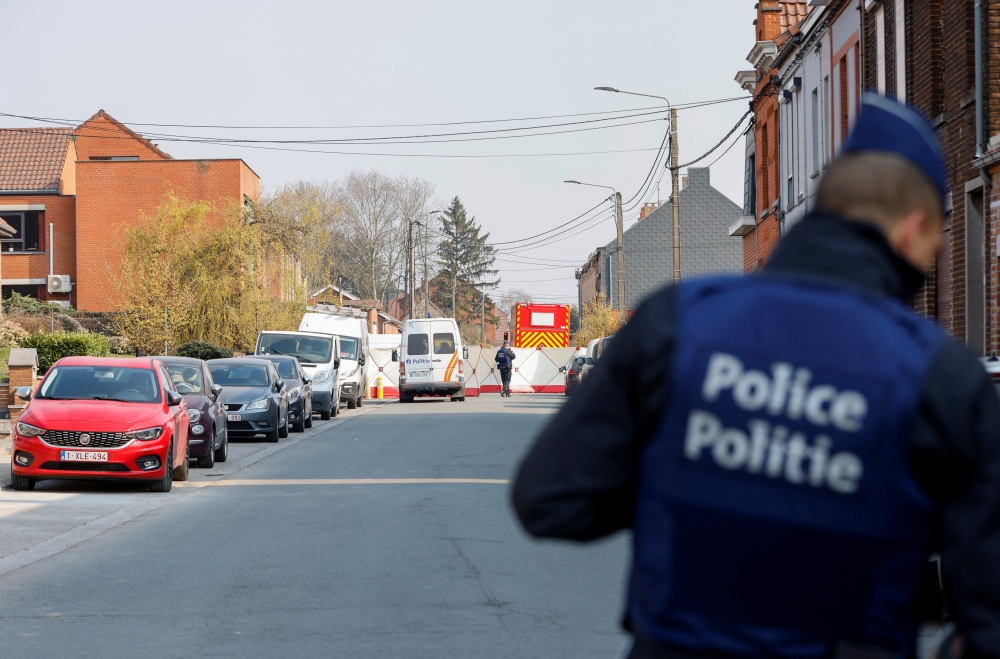 Police officers patrol at the site where a vehicle drove into a group of Belgian carnival performers who were preparing for a parade in the village of Strepy-Bracquegnies, Belgium March 20, 2022. REUTERS/Johanna Geron