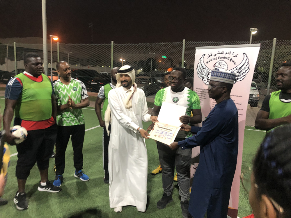 Ambassador of Nigeria to Qatar H E Yakubu Abdullahi Ahmed and NIDO-Qatar President Ajibade Lateef receiving the certificate of affiliation from IWFF Asia and Qatar President, Farhan Al Sheikh Al Sayed.