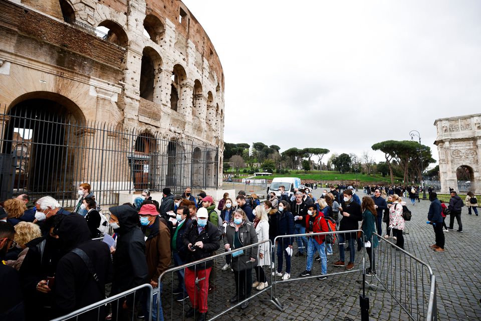 People wait in line before entering the Colosseum as Italy begins to ease some of the coronavirus disease (COVID-19) restrictions, lifting the obligation to show a health pass to sit at outdoor restaurants, access museums and other activities in Rome, Italy, April 1, 2022. REUTERS/Guglielmo Mangiapane




