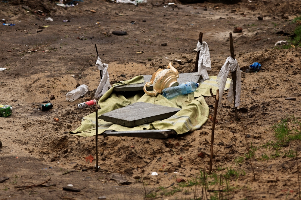 A grave where two men have been buried, who according to residents were shot dead in the eye by Russian soldiers, is seen at the garden of a building, amid Russia's invasion on Ukraine, in Bucha, Ukraine April 3, 2022. REUTERS.