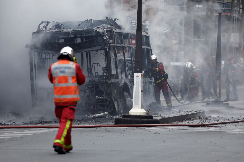 Firefighters work at the scene where a bus caught fire in Paris, France, April 4, 2022. REUTERS/Benoit Tessier