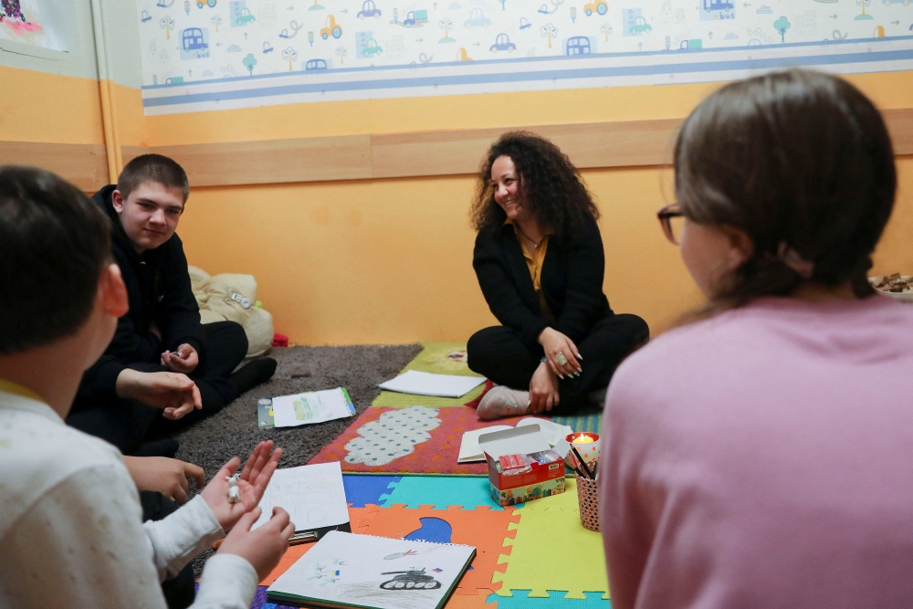 Regina Nasretdinova interact with Ukrainian children, who fled the Russian invasion of Ukraine, during an art therapy class at the Berehynia Cultural and Educational Center in Athens, Greece, March 28, 2022. REUTERS/Louiza Vradi
