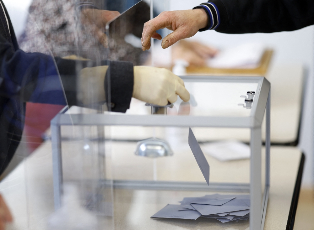 A voter casts their ballot in the first round of the 2022 French presidential election at a polling station in Pontaumur, France, April 10, 2022. Reuters/Stephane Mahe