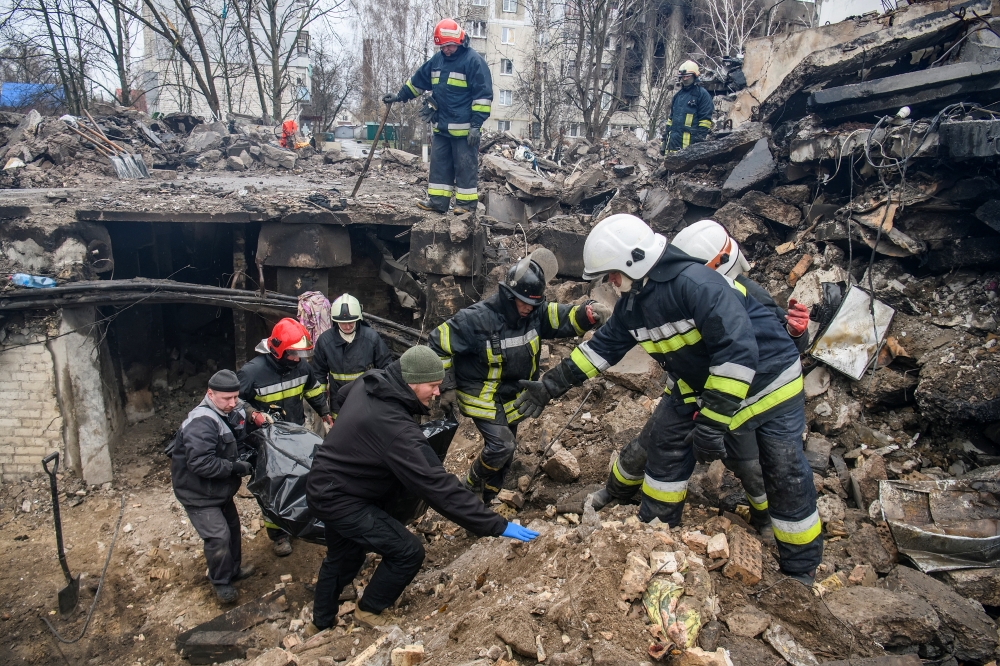 Rescuers carry a body of a person found under debris of a residential building destroyed during Russia's invasion in the town of Borodianka, Kyiv region, Ukraine April 9, 2022. Reuters/Vladyslav Musiienko