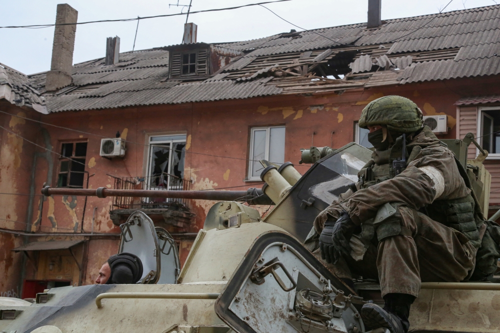 Service members of pro-Russian troops drive an armoured vehicle during Ukraine-Russia conflict in the southern port city of Mariupol, Ukraine April 11, 2022. Reuters/Chingis Kondarov 