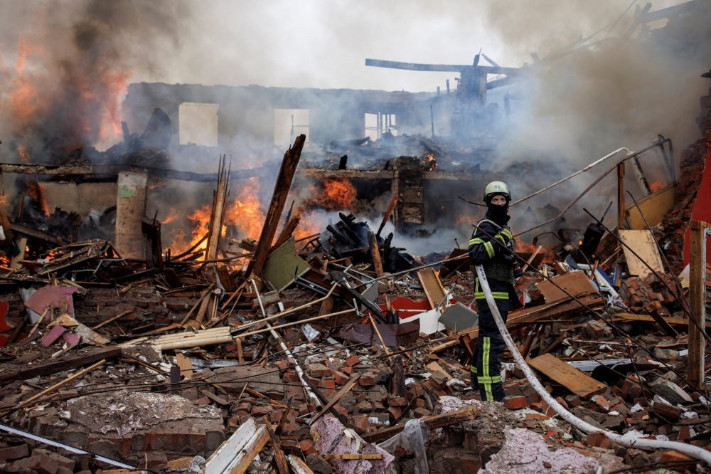 A firefighter holds a hose next to a burning building, following a missile attack near the Kharkiv International Airport, as Russia's attack on Ukraine continues, in Kharkiv, Ukraine, April 12, 2022. Picture taken April 12, 2022. REUTERS/Alkis Konstantinidis