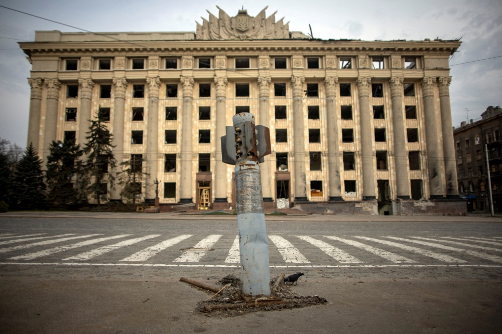 A bird is seen next to a missile from a previous Russian military attack as the damaged Kharkiv Regional State Administration building seen in the background, amid Russia's attack on Ukraine, in Kharkiv, Ukraine, April 11, 2022. REUTERS/Alkis Konstantinidis 