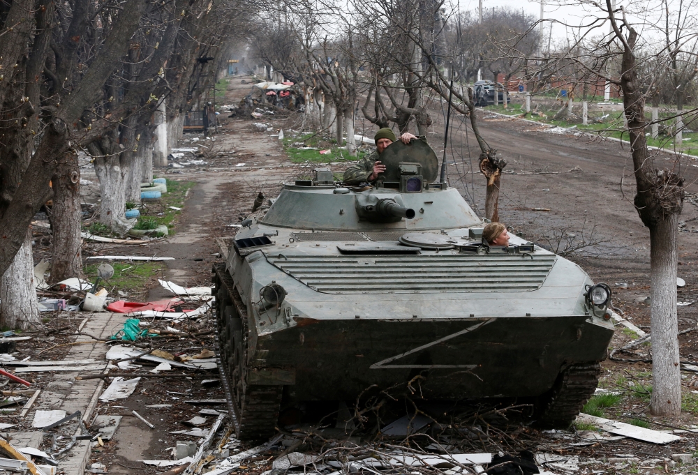 Service members of pro-Russian troops ride an armoured vehicle during fighting in Ukraine-Russia conflict near a plant of Azovstal Iron and Steel Works company in the southern port city of Mariupol, Ukraine April 12, 2022. Reuters/Alexander Ermochenko