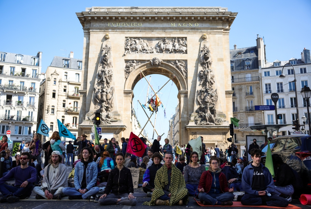Activists from Extinction Rebellion occupy the Porte Saint Denis, as part of an action to demand ecological and social justice ahead of the second round of the 2022 presidential election, in Paris, France, April 16, 2022. Reuters/Sarah Meyssonnier