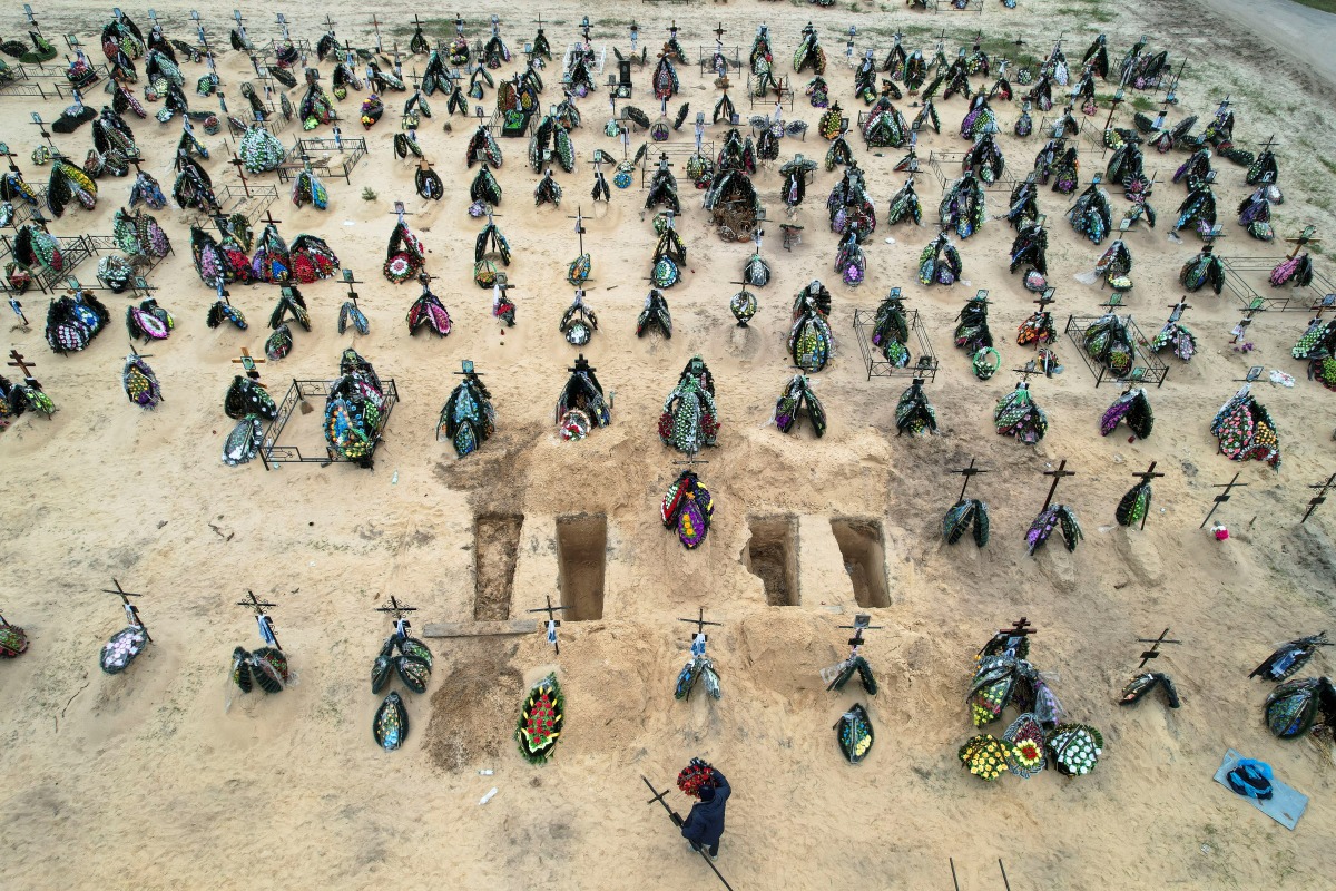 A view of at least three rows of new graves for people killed during Russia's invasion of Ukraine, at a cemetery in Irpin, Kyiv region, Ukraine April 18, 2022. Picture taken with a drone. REUTERS/Zohra Bensemra 