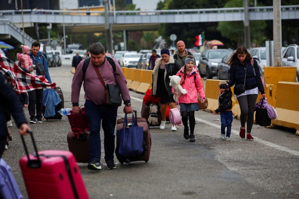 Ukrainians who fled to Mexico amid Russia's invasion of their homeland, walk with their belongings to cross the San Ysidro Land Port of Entry of the U.S.-Mexico border, in Tijuana, Mexico April 2, 2022. REUTERS/Jorge Duenes/File Photo



