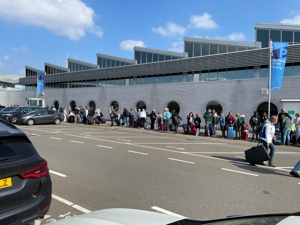 Travellers wait in a line outside Amsterdam Schiphol Airport as an unannounced strike of ground staff caused many delays and cancellations, in Amsterdam, Netherlands April 23, 2022. REUTERS/Anthony Deutsch