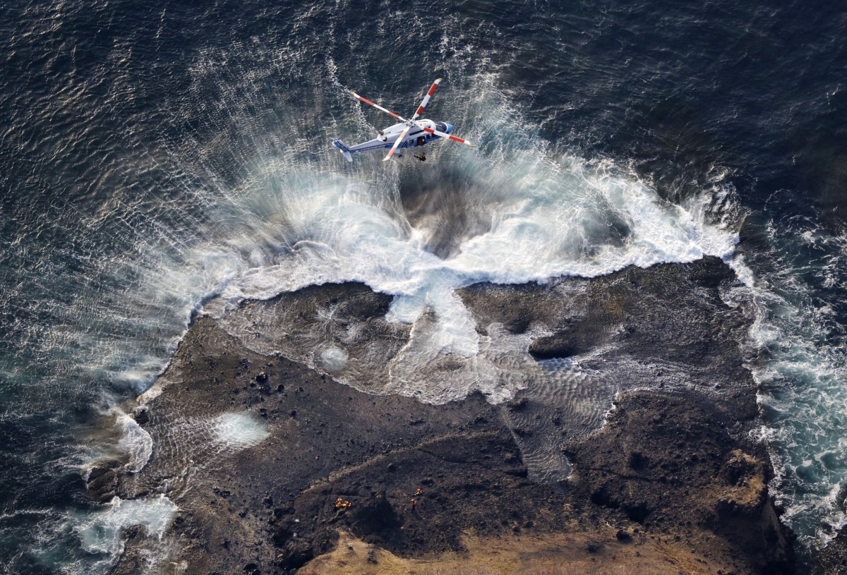 An aerial view shows a Japan Coast Guard helicopter conducts a search and rescue operations for missing people boarded on the missing tour boat 