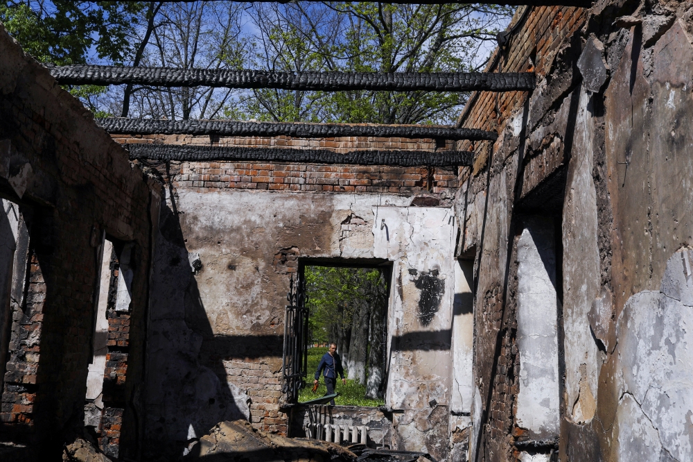 A man walks outside the Hryhoriy Skovoroda Literary Memorial Museum after a Russian bombing hit it, amid Russia's attack on Ukraine, in Skovorodynivka village near Kharkiv, Ukraine, May 7, 2022. REUTERS/Ricardo Moraes