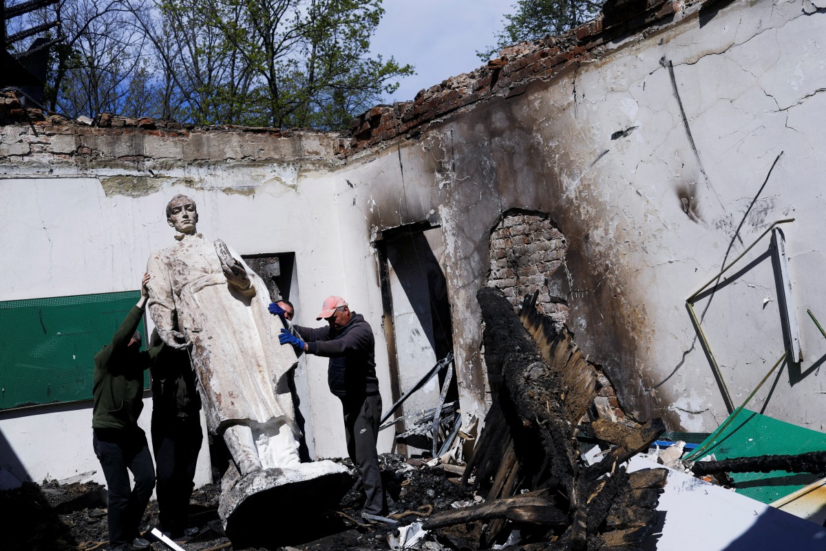 Employees remove the statue of Ukrainian philosopher Hryhoriy Skovoroda after a Russian bombing hit the Hryhoriy Skovoroda Literary Memorial Museum, amid Russia's attack on Ukraine, in Skovorodynivka village near Kharkiv, Ukraine, May 7, 2022. REUTERS/Ricardo Moraes TPX IMAGES OF THE DAY

