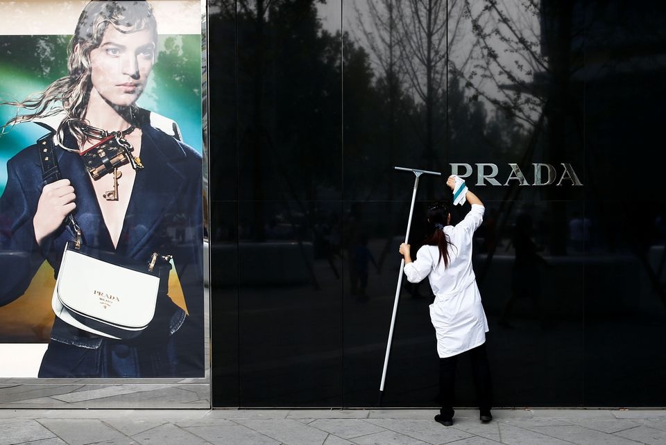 A woman cleans the brand logo at a Prada fashion boutique in Beijing, China, September 16, 2016. REUTERS/Thomas Peter/Files


