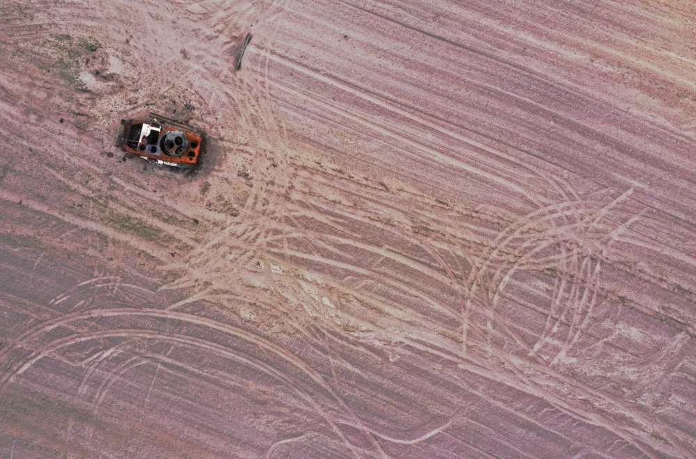 A military vehicle is pictured in a grain field previously mined with explosives, amid the Russian invasion of Ukraine, in Chernihiv region, Ukraine May 24, 2022. Picture taken with drone. REUTERS/Edgar Su/File Photo