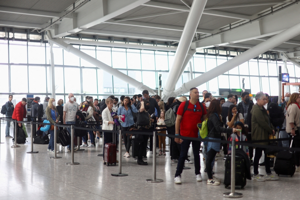 File photo of passengers' queue to enter airport security ahead of the Easter Bank Holiday weekend, at Terminal 5 of Heathrow Airport, in London, Britain, April 14, 2022. Reuters/Hannah McKay/File Photo
 