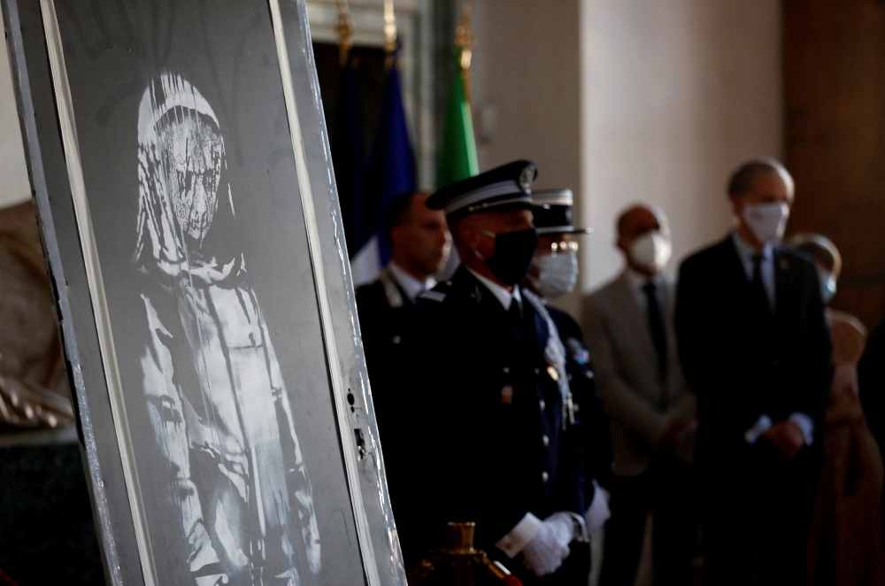 File photo: A mural by anonymous British street artist Banksy stolen from the Bataclan theatre in Paris and found in a farmhouse in central Italy is seen during the ceremony to return to France at the French embassy in Rome, Italy. July 14, 2020. Reuters/Yara Nardi/File Photo