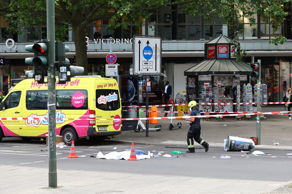 A covered body lies on the road after a car crashed into a group of people before hitting a storefront at Tauentzienstrasse in Berlin, Germany June 8, 2022. Reuters/Fabrizio Bensch