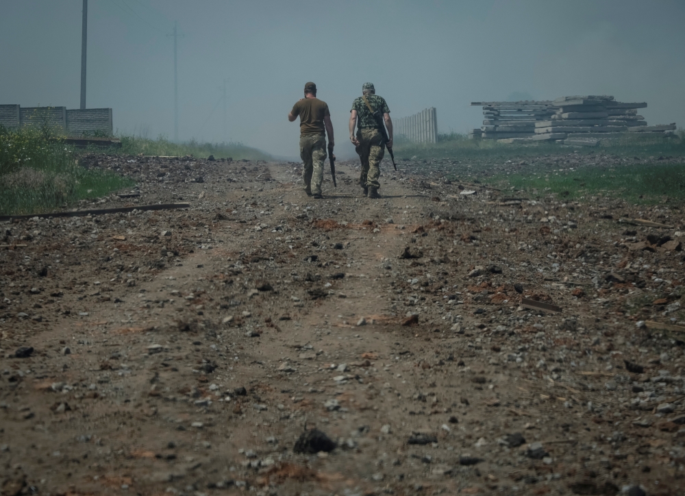 Ukrainian service members walk on the road near the town of Soledar, amid Russia's invasion of Ukraine, Donetsk region, Ukraine June 8, 2022. REUTERS/Gleb Garanich