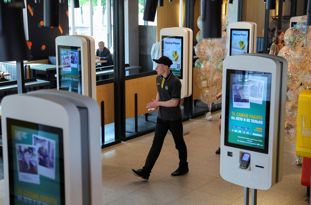 An employee takes part in preparations before the opening of a new restaurant in Moscow, Russia June 12, 2022. Reuters/Evgenia Novozhenina