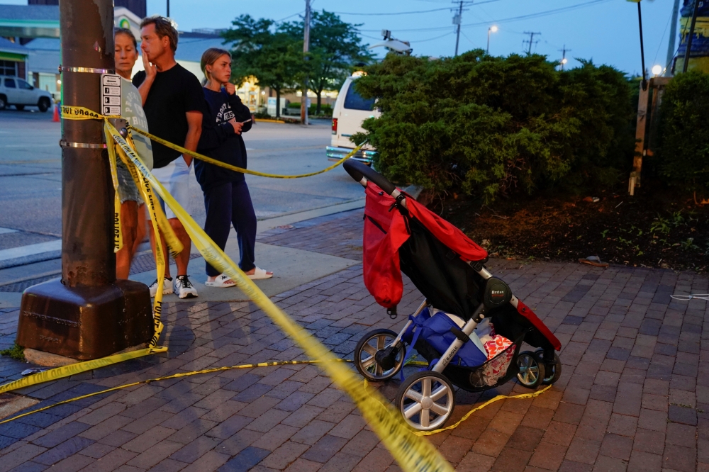 Community members visit the the site of a mass shooting at a Fourth of July parade route in the Chicago suburb of Highland Park, Illinois, U.S. July 4, 2022. REUTERS/Cheney Orr