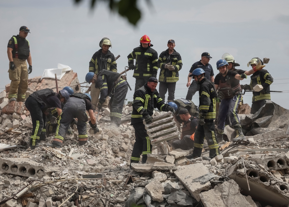 Rescuers work at a residential building damaged by a Russian military strike in the town of Chasiv Yar, in Donetsk region, Ukraine on July 10, 2022. (REUTERS/Gleb Garanich)