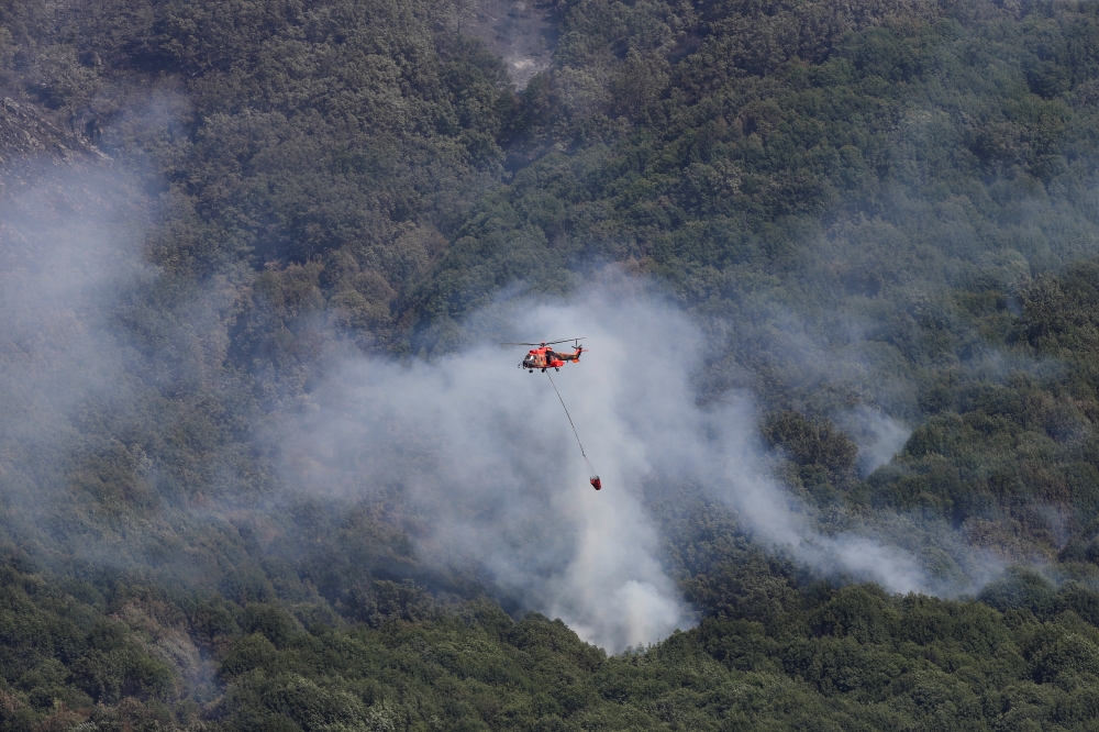 A helicopter works to contain a wildfire at Garganta de los Infiernos natural reserve, as the country experiences its second heatwave of the year, in Jerte, Spain, July 17, 2022. (REUTERS/Isabel Infantes)