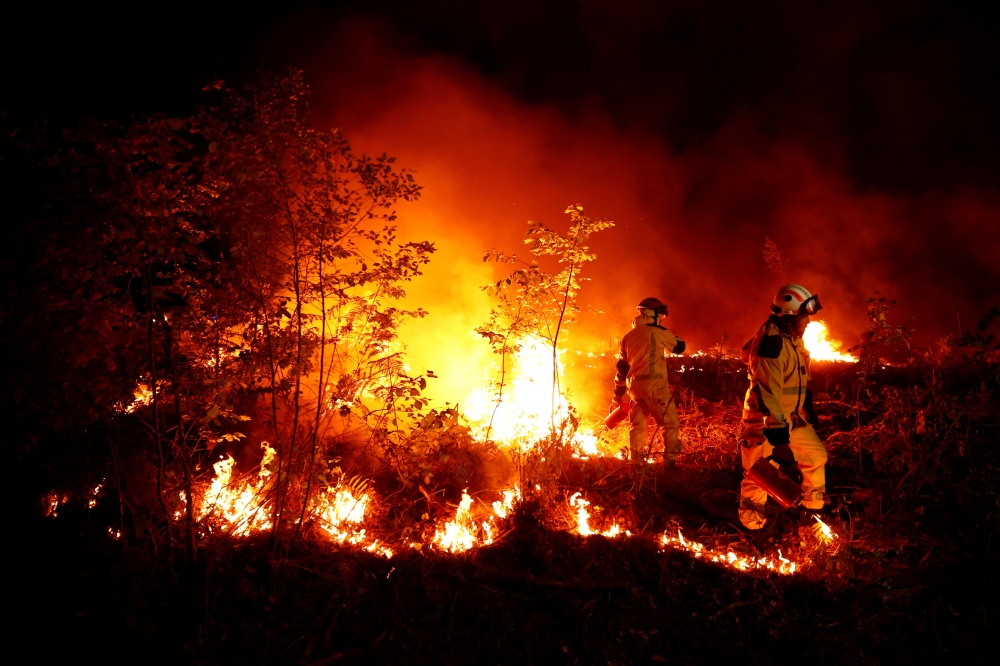 Firefighters create a tactical fire in Louchats, as wildfires continue to spread in the Gironde region of southwestern France, July 17, 2022. REUTERS/Sarah Meyssonnier