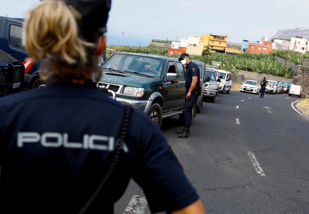 File Photo: A female police officer stands guard on the Canary Island of La Palma, in La Laguna, Spain, September 21, 2021. (REUTERS/Borja Suarez)
