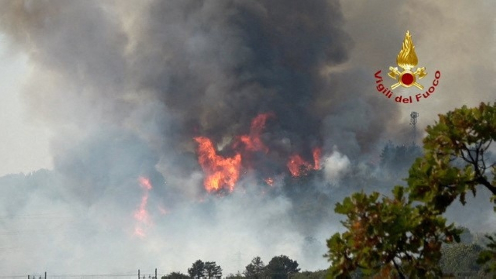 Firefighters battle wildfires in Duino, near Trieste, Italy, July 20, 2022, in this screengrab taken from a video. Vigili del Fuoco/Handout via REUTERS