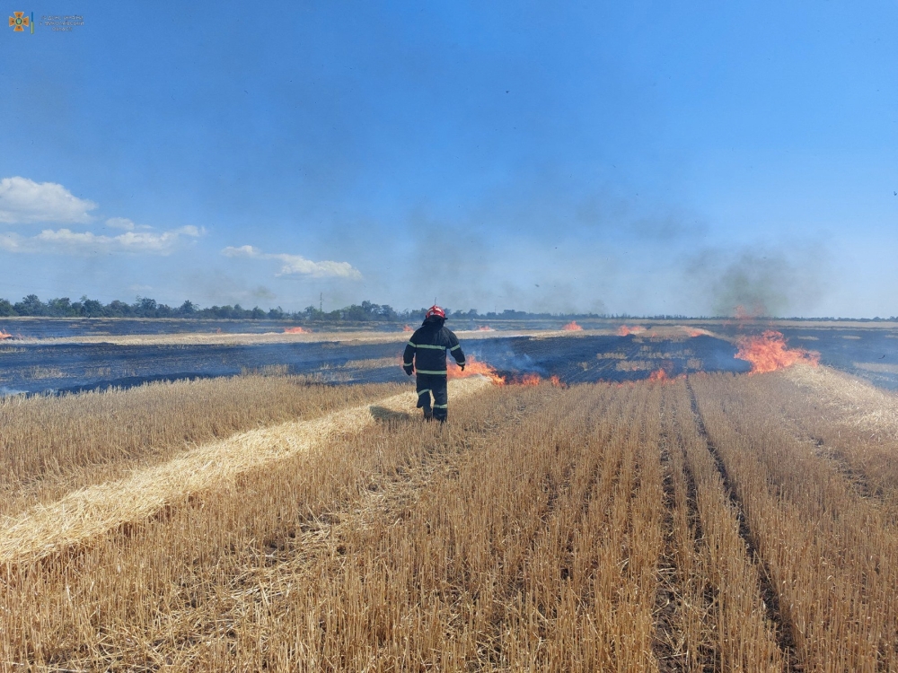 A firefighter works in a field, which burns after a military strike, as Russia's attack on Ukraine continues, in Mykolaiv region, Ukraine, in this handout picture released July 27, 2022. Press service of the State Emergency Service of Ukraine/Handout via REUTERS ATTENTION EDITORS - THIS IMAGE HAS BEEN SUPPLIED BY A THIRD PARTY.