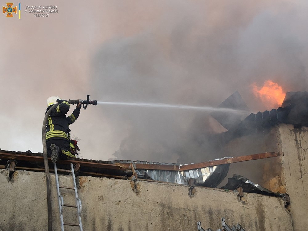 A firefighter works to douse a fire in a building, as Russia's attack on Ukraine continues, in Mykolaiv, in this handout picture released on July 31, 2022. (Reuters)

